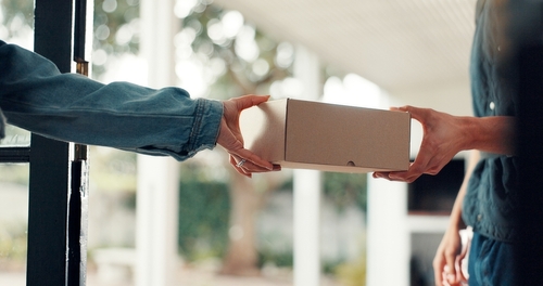 BoxDeliveryAndHandsOfPeopleInHomeForDirect